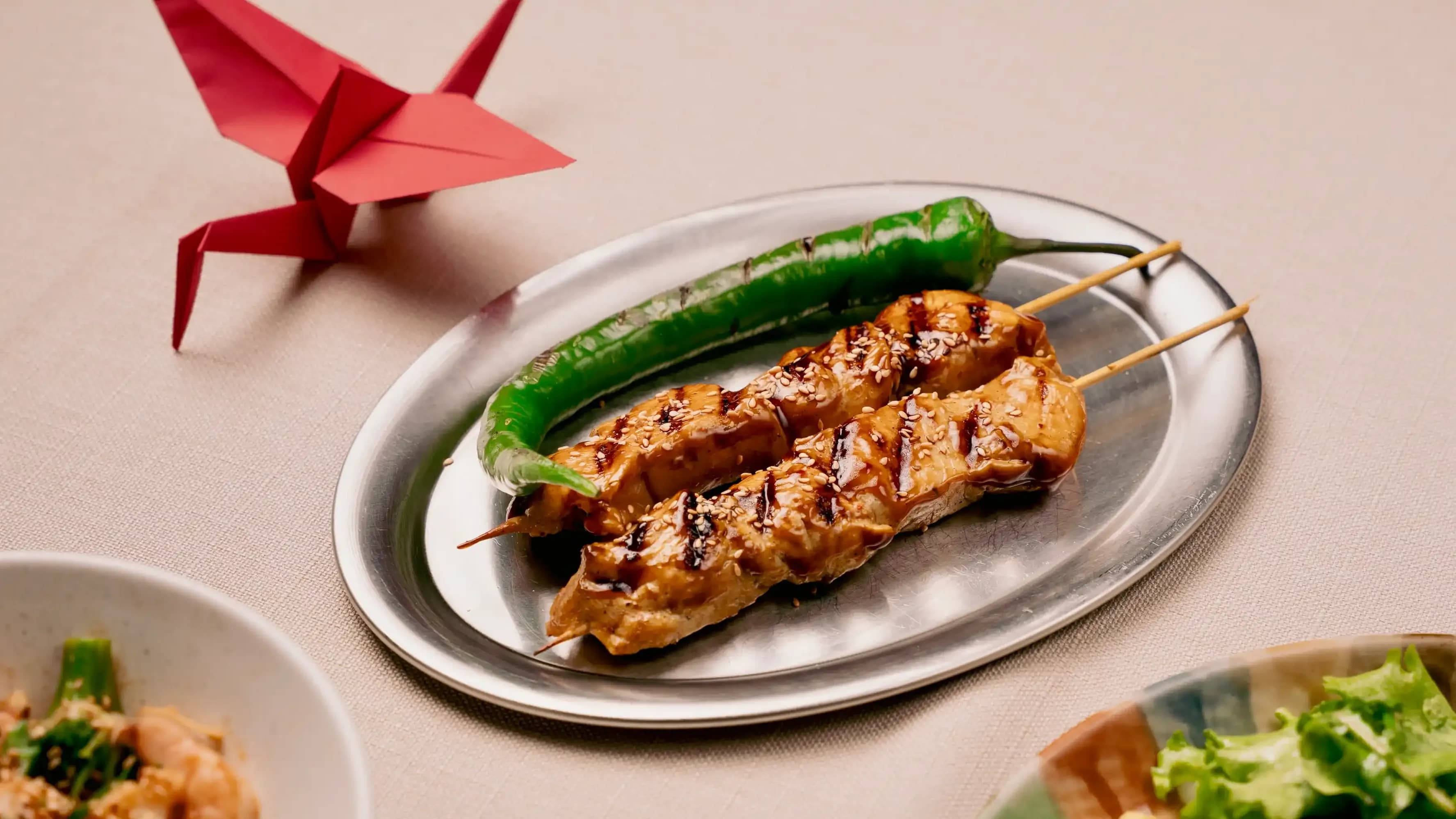 Teriyaki sosu o matotta yakitori, kobashi goma o tirasite